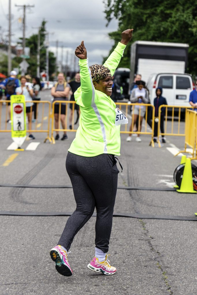 A woman is participating in the West Seattle 5K race.